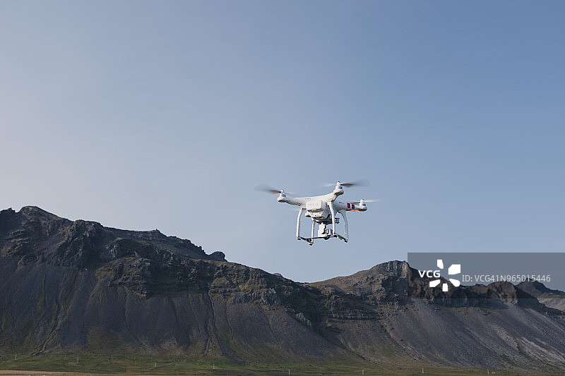 低角度的无人机飞行对抗山脉和晴朗的天空图片素材