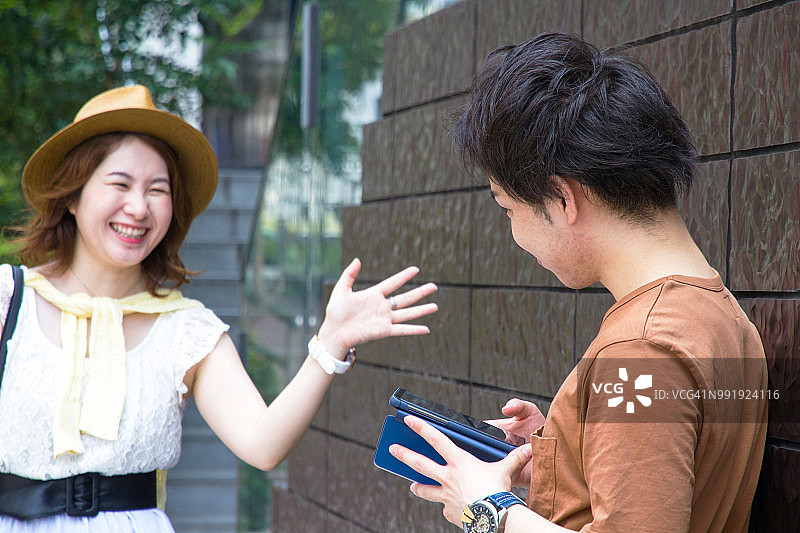 一对快乐的年轻亚洲夫妇在外面约会。图片素材