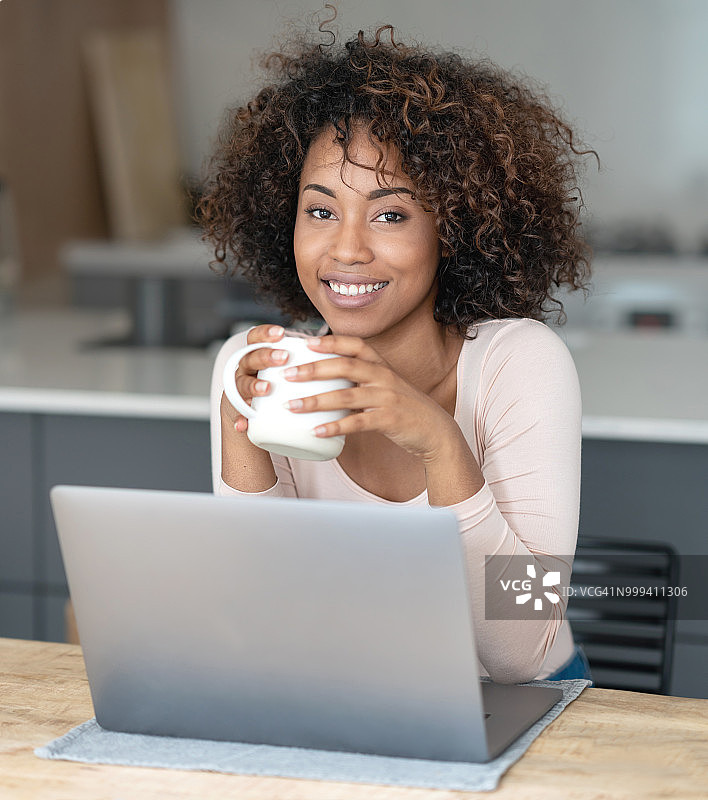 快乐的非裔美国女人在家用笔记本电脑上网工作图片素材