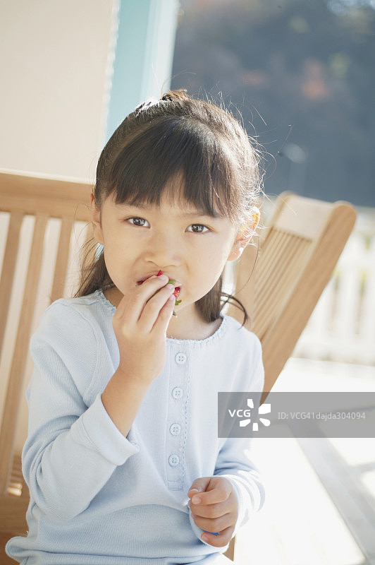 一个小女孩在吃草莓图片素材