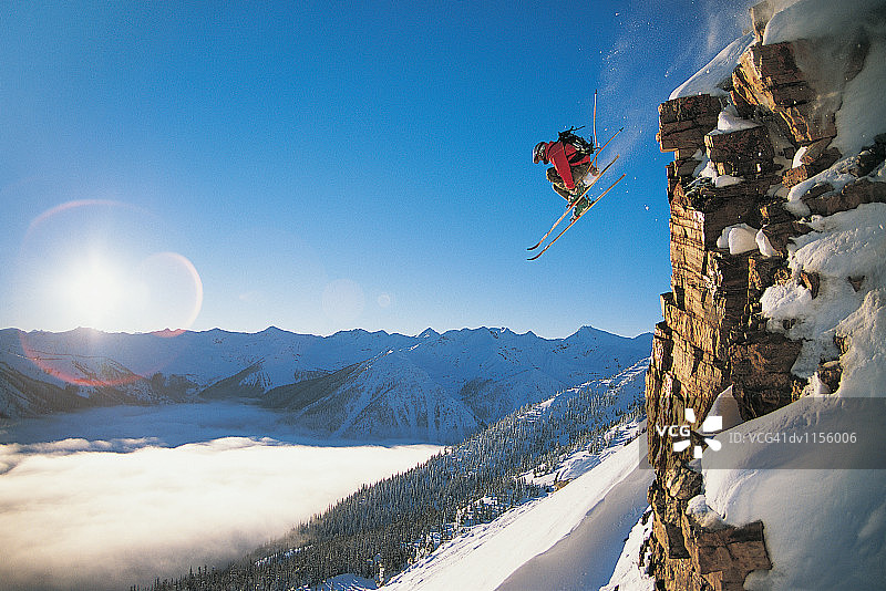 滑雪者跳半空中从陡峭的岩石面滑雪道图片素材