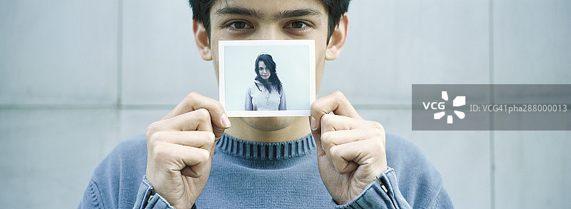 一个年轻人举着一个年轻女人的照片图片素材