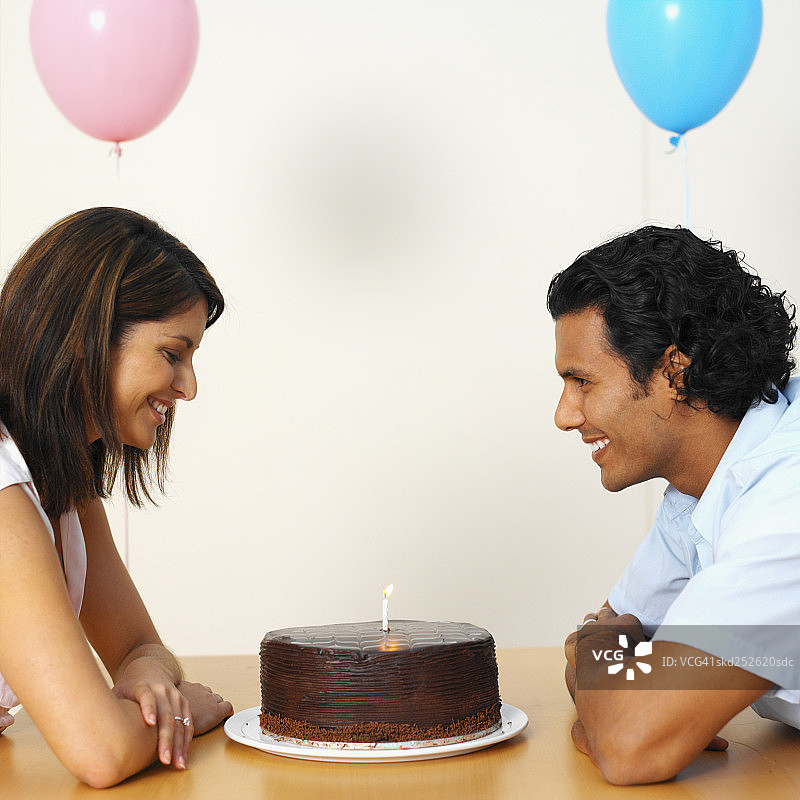 一对夫妇的生日蛋糕和气球的侧视图图片素材
