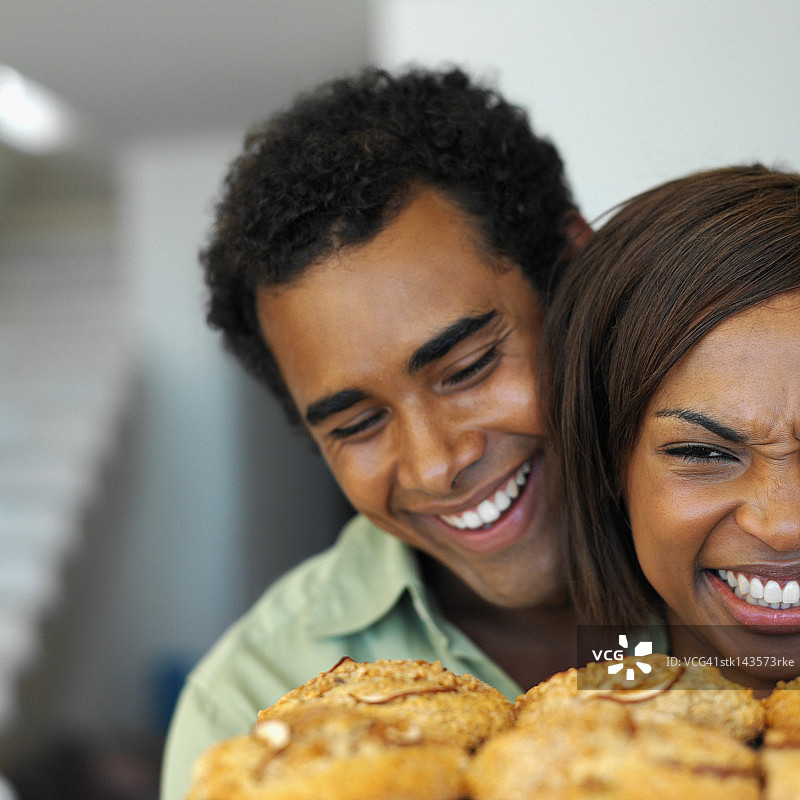 近距离观看一对夫妇微笑着看着新鲜制作的饼干图片素材