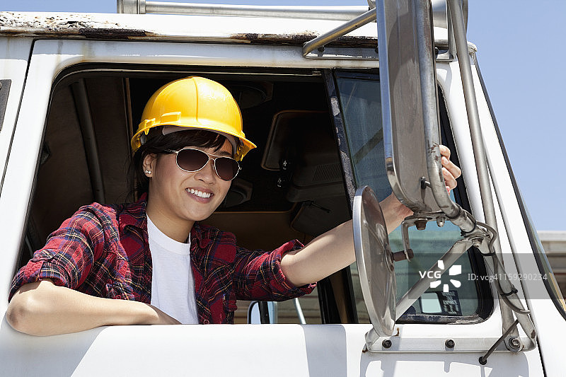 女产业工人坐在伐木卡车上调整镜子图片素材