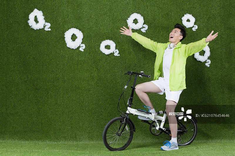 草地创意男青年骑自行车图片素材