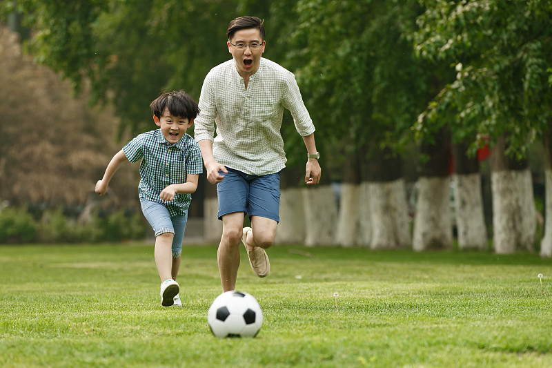 快乐父子在草地上踢足球图片下载