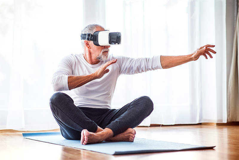老人戴着VR眼镜在家锻炼。图片下载