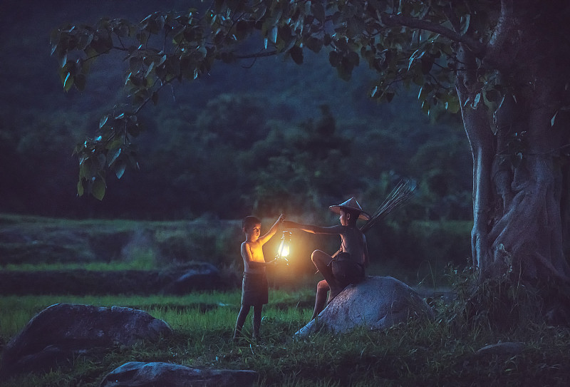 两个亚洲男孩晚上在树下提灯笼图片素材