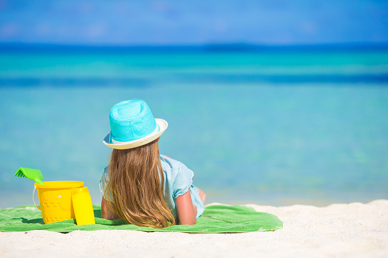 可爱的小女孩戴着帽子在暑假的海滩上图片下载
