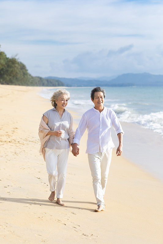 快乐的老年夫妇在沙滩散步图片下载