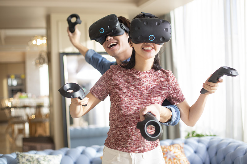 年轻情侣在家玩VR游戏图片下载
