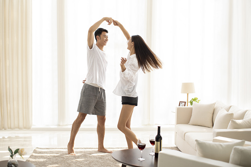 年轻情侣在客厅跳舞图片素材