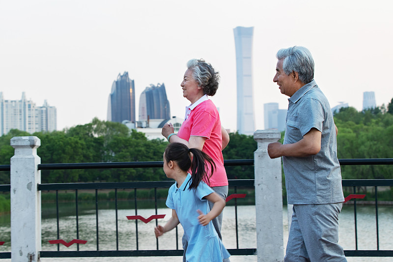 老年夫妇带着孙女在户外跑步图片素材