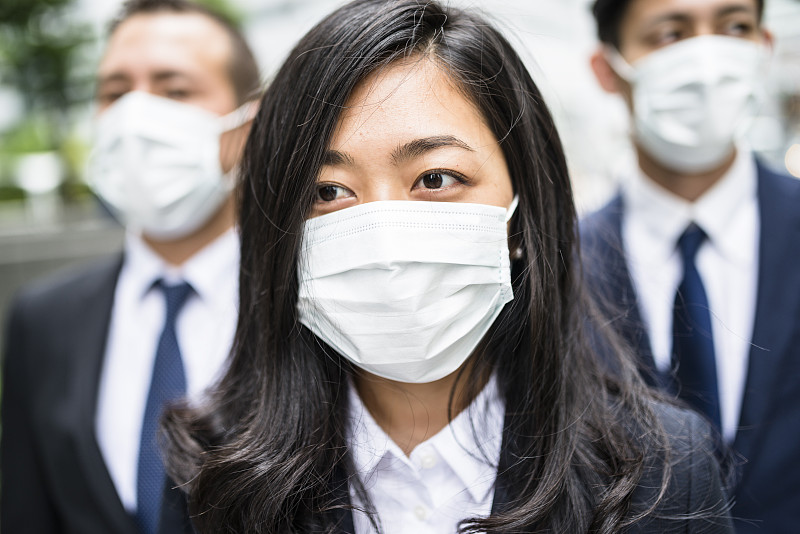 日本商人戴着污染口罩在东京图片下载