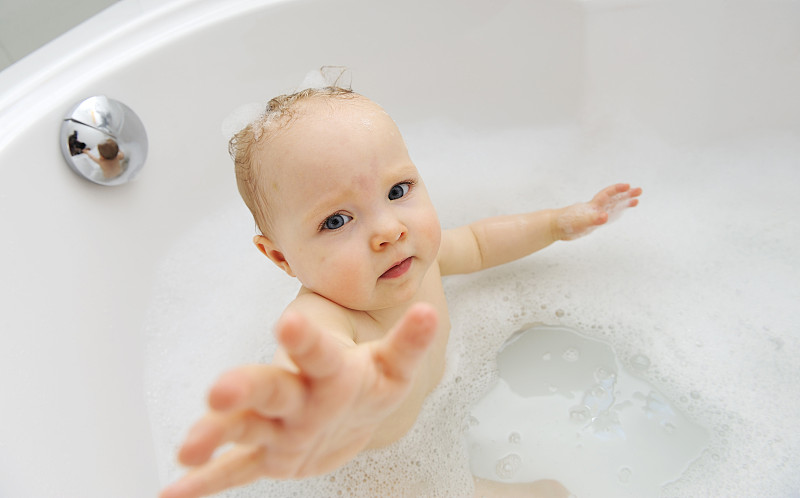 女婴在浴缸里伸着胳膊图片下载