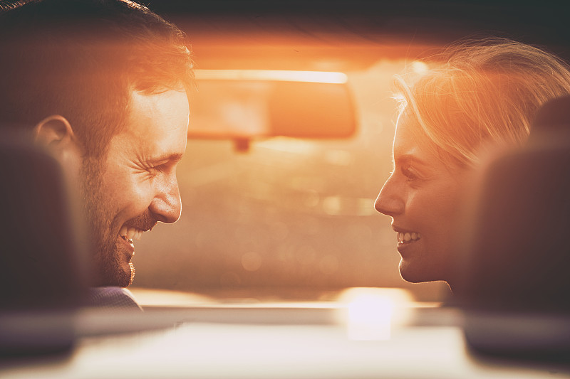 日落时分，一对幸福的夫妇在车里聊天。图片素材