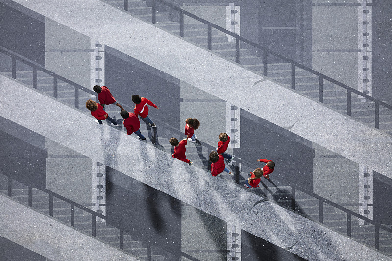 学生们穿着红色的衣服，走过粉刷过的楼梯图片素材