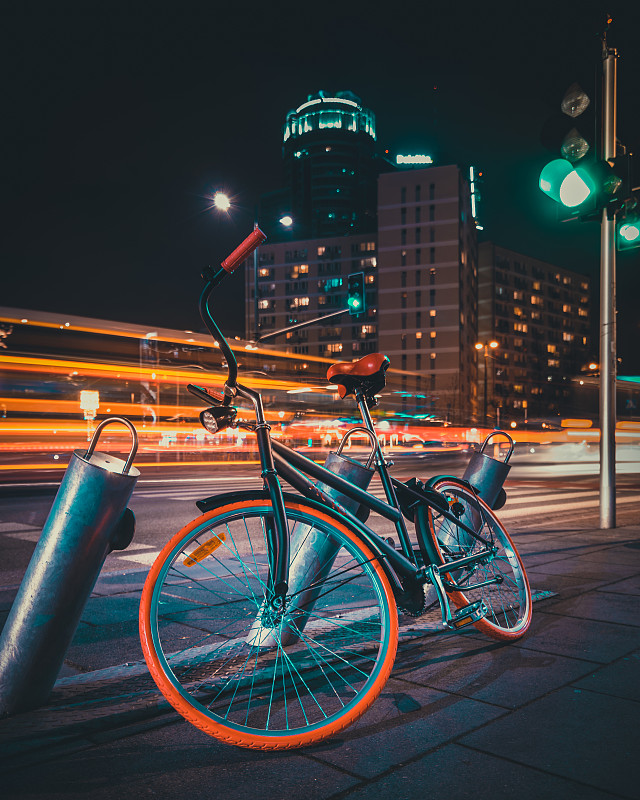 在路灯照亮的夜晚，自行车停在街道上图片下载