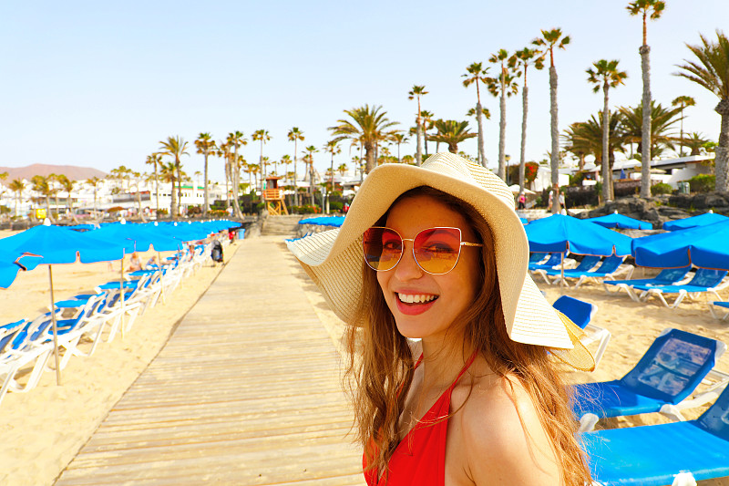 在海滩上戴太阳镜的年轻女人的肖像图片素材