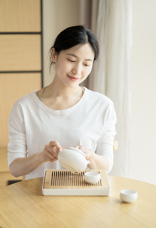 年轻的中国妇女正在喝茶图片下载