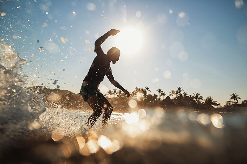 男冲浪者骑在阳光明媚的夏季海洋，Sayulita，纳亚里特，墨西哥图片下载