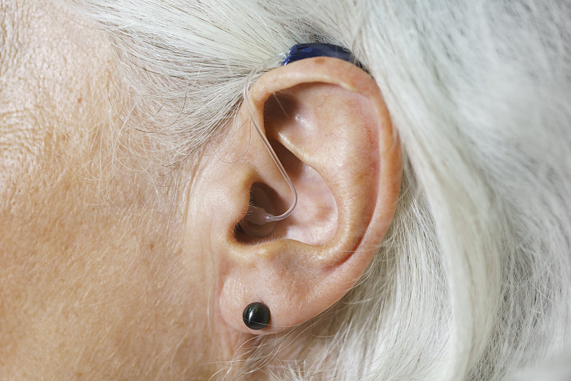 特写的女人灰色头发戴着助听器图片下载