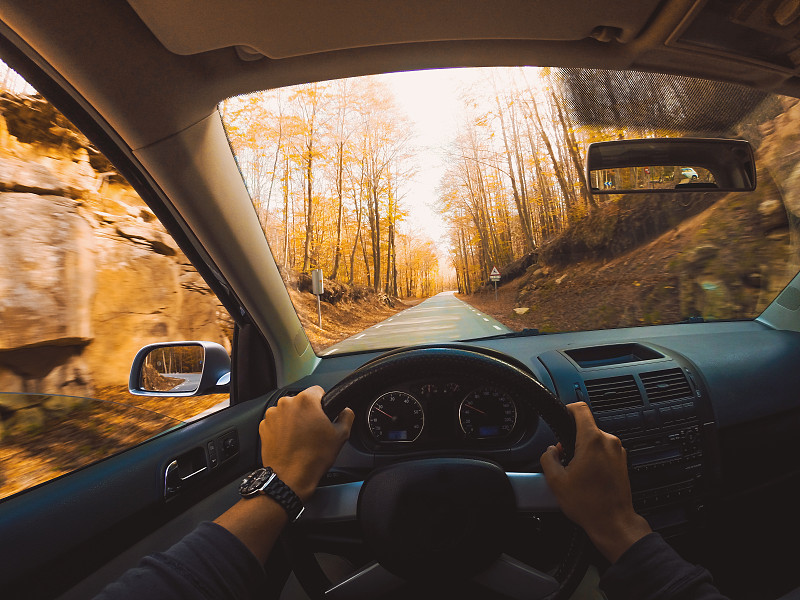在巴塞罗那市附近的蒙特塞尼自然保护区，从个人的角度驾驶汽车在森林之间的美丽山路上的秋天的颜色。图片下载