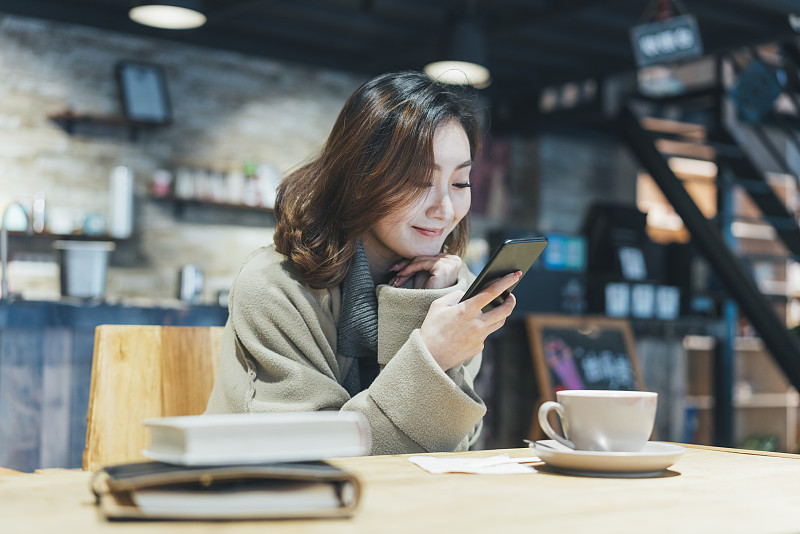 一个在咖啡厅喝咖啡发短信的女人图片下载