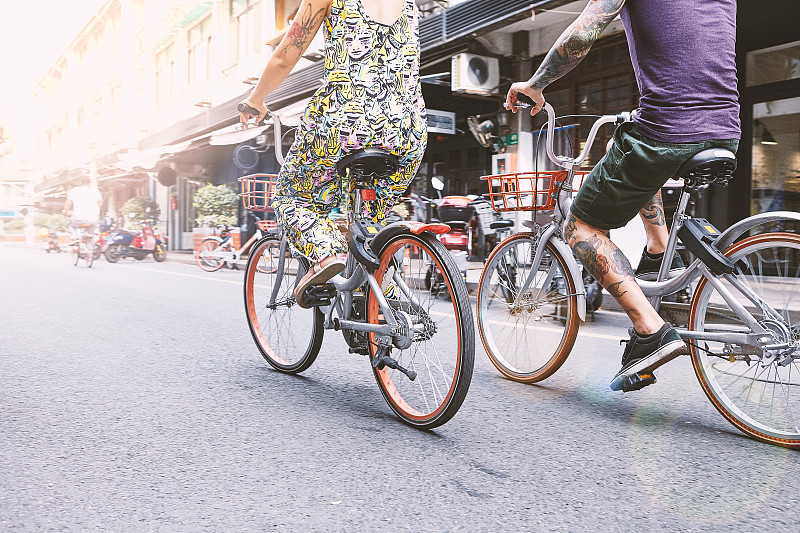 多民族潮人夫妇骑自行车沿着街道，上海法租界，上海，中国图片下载