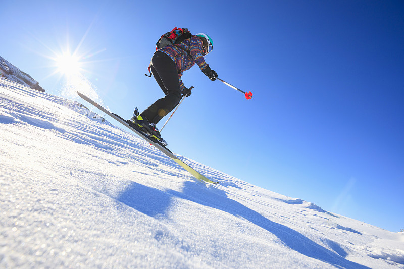 女子滑雪滑雪在阳光明媚的滑雪胜地滑雪业余冬季运动。高山雪景。意大利阿尔卑斯山脉的白云石圣母迪坎皮里奥，意大利。图片下载