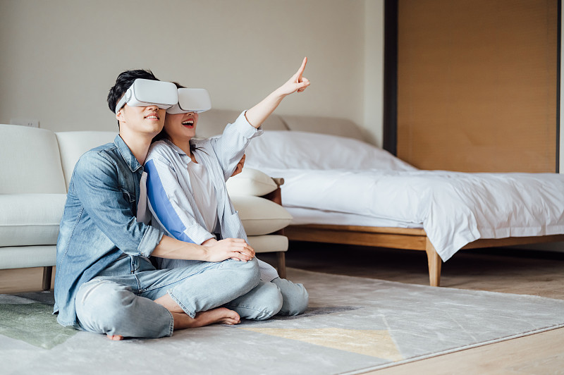 亚洲年轻情侣在家使用VR眼镜图片素材