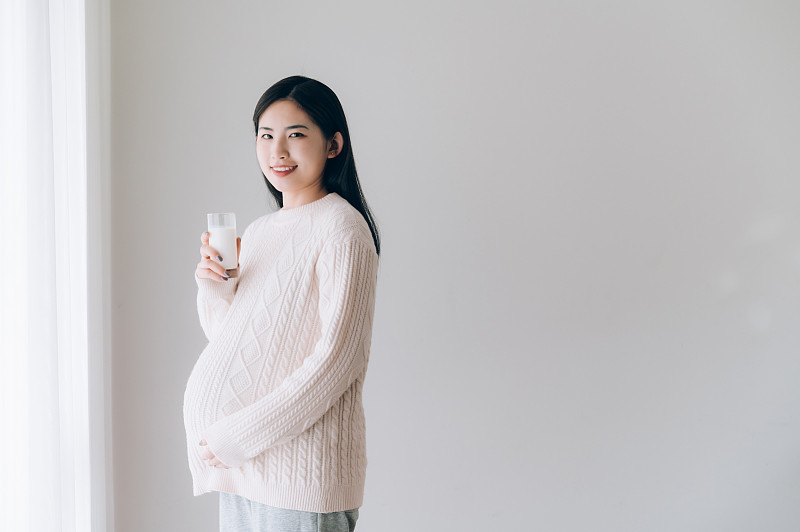 亚洲年轻孕妇喝牛奶图片素材