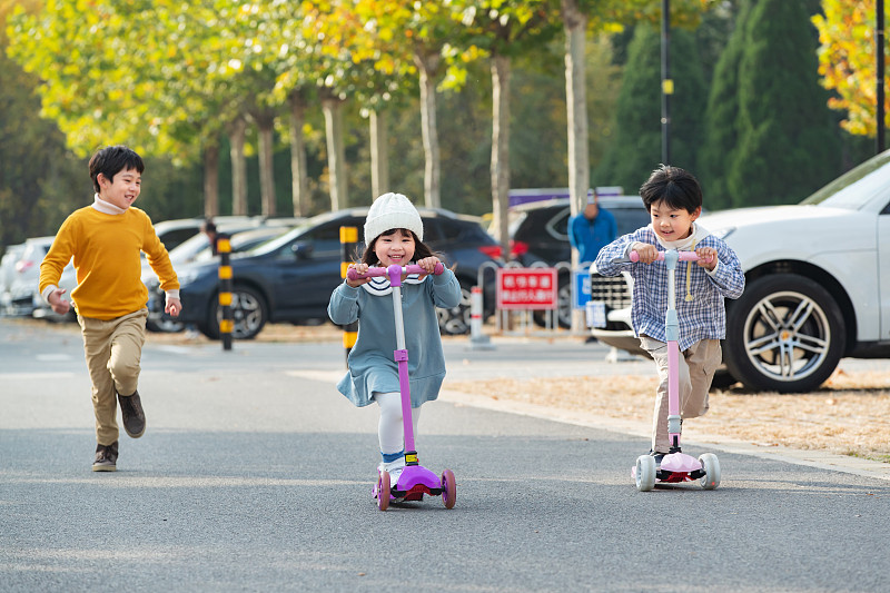 快乐的儿童在户外玩滑板车图片下载