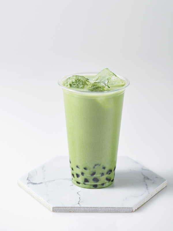 绿茶奶茶与木薯珍珠和冰在白色的背景图片素材