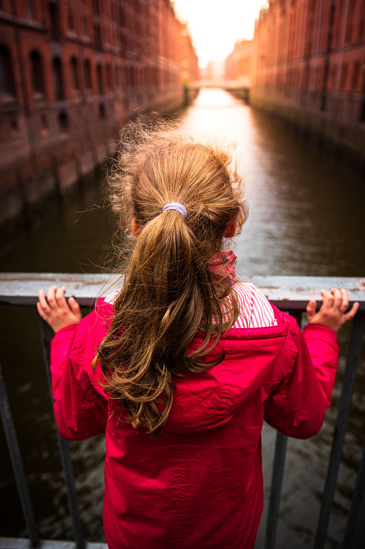 德国阿尔茨塔特市，站在运河桥上的女孩的后视图图片素材