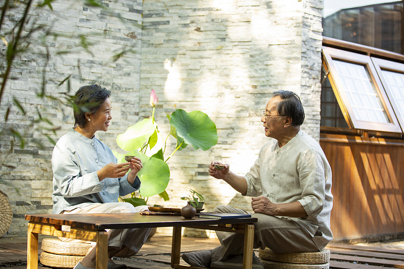 老年夫妻在户外庭院喝茶闲谈图片素材