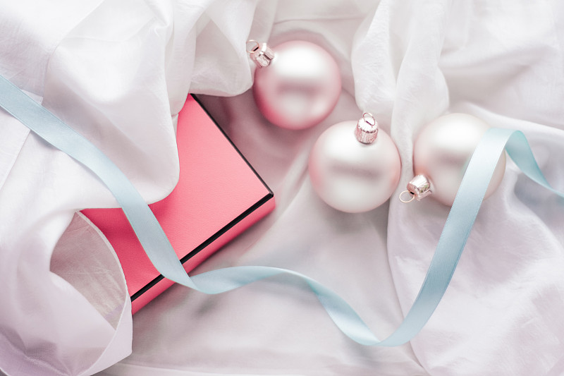 圣诞装饰和礼品盒与闪亮的雪在丝绸的背景图片下载