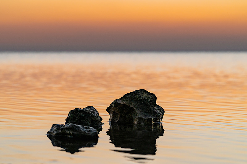 呆着别动，卡塔尔，日落时分，海上岩石与天空的特写图片下载