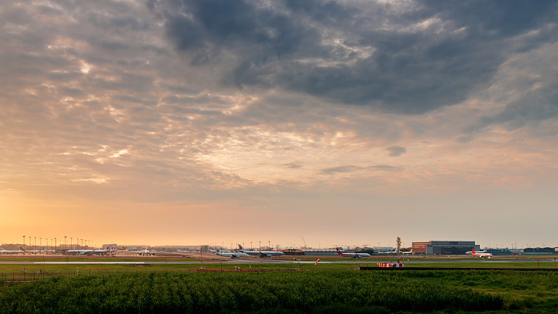 成都双流机场，日出时分，太阳刚刚染红天空，机场早已忙碌起来了图片下载
