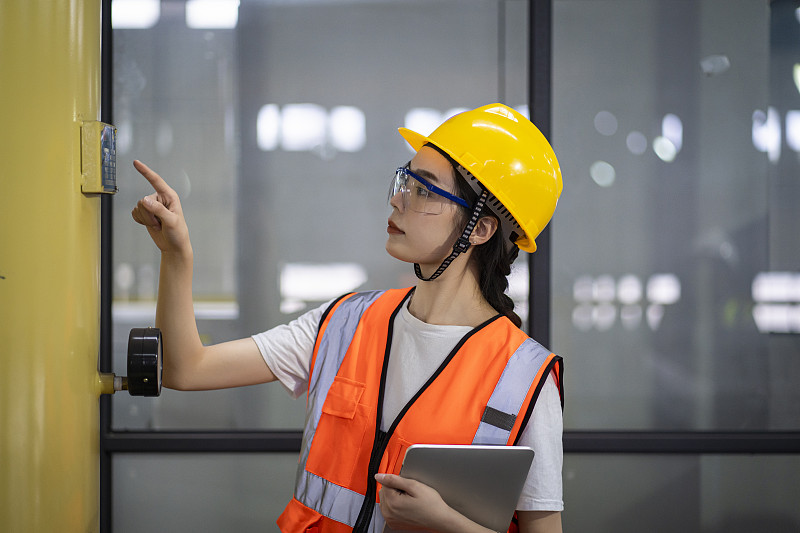 手拿平板电脑在工厂车间检查工作的女工程师图片下载