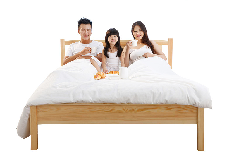 幸福的一家三口在床上吃早餐图片下载