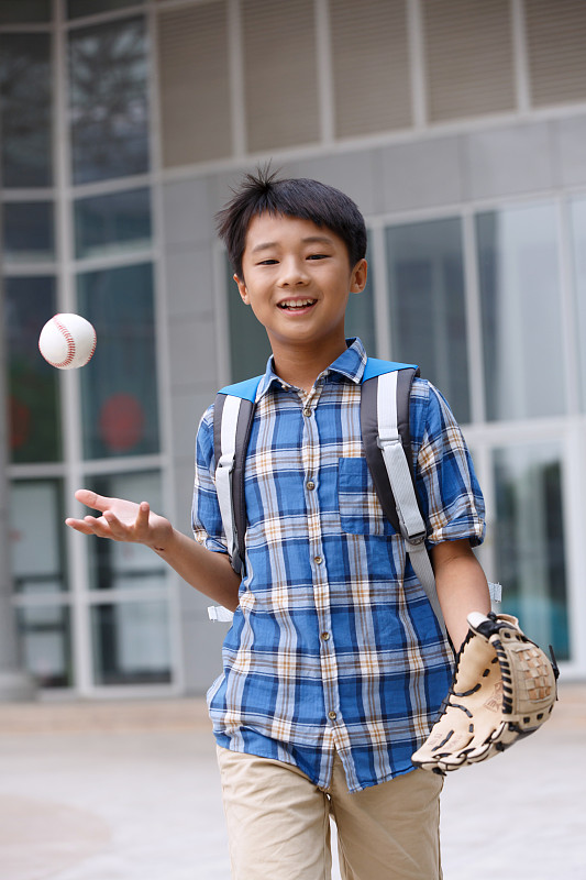小学生在校园里拿着棒球图片素材