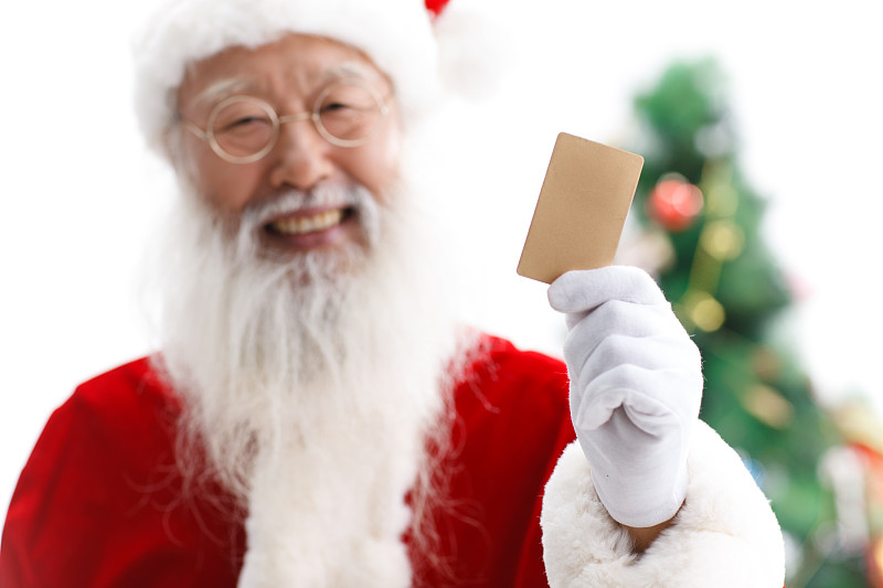 穿着圣诞服的老年男人拿着卡片图片素材