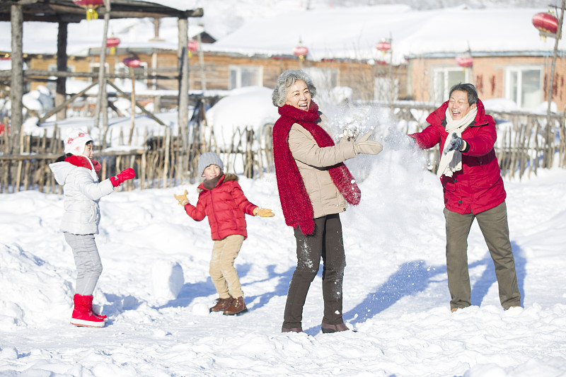 快乐的家庭在雪地上打雪仗图片下载