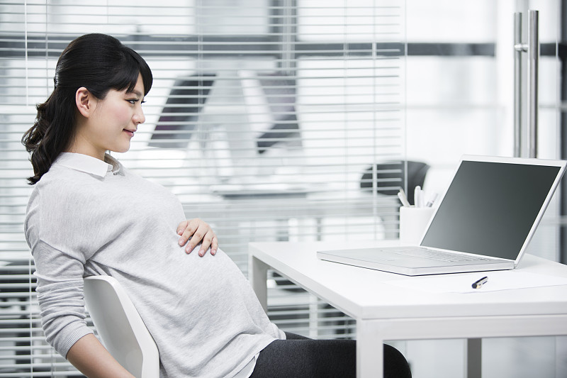 怀孕的商务女士在办公室图片素材