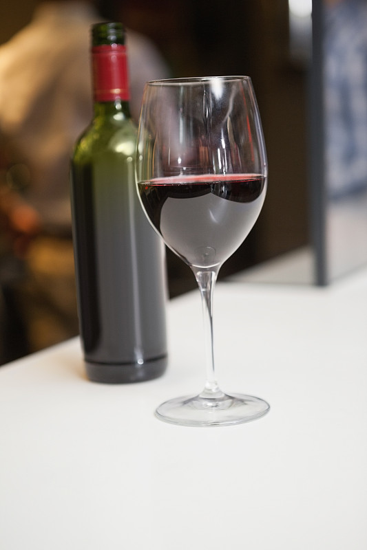 近距离的红酒进入玻璃前的酒瓶在一个酒吧图片素材
