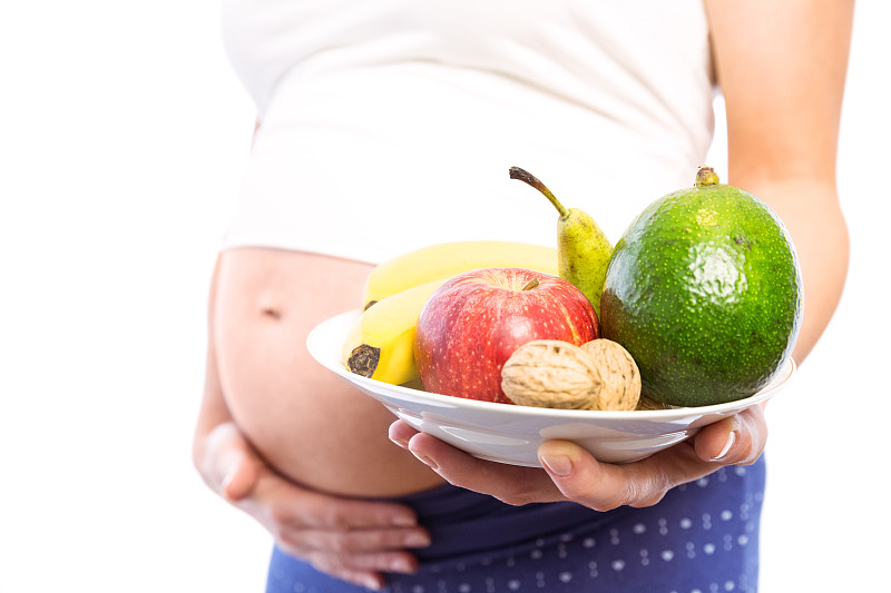 孕妇在白色背景上显示水果和蔬菜图片下载
