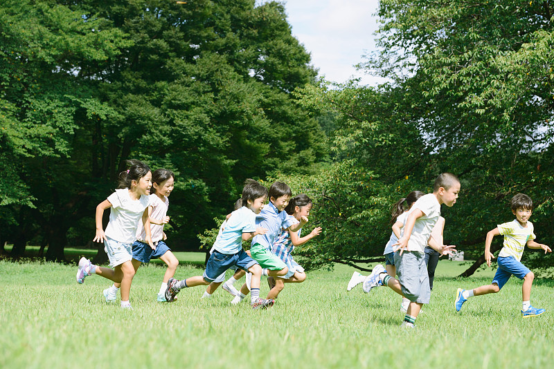 日本孩子在城市公园里跑步图片下载