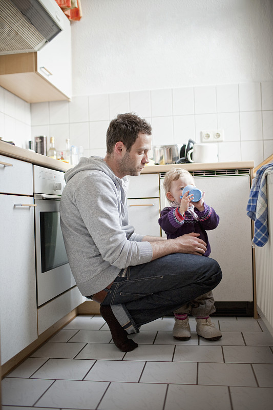 父亲与婴儿女儿(6-12个月)在厨房图片素材